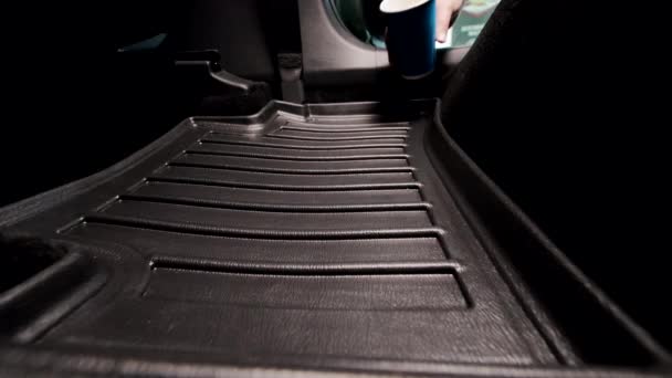 把咖啡洒在车上的地毯上 小木屋里汽车的污染 一杯装有咖啡的蓝色一次性杯子落在车底垫子上 — 图库视频影像