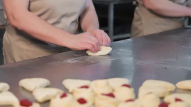 Kadın eli çilek dolgulu kurabiye yapar. Kadın eli, kurabiye zarfı yapar. Kapat..