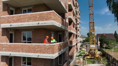 Bir mühendis ve bir mimar evin inşa ve haberleşme planını göz önünde bulundururlar. Ev yapım aşamasında