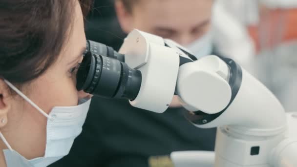 Uma Médica Feminina Olha Microscópio Perto Visão Lateral Cientista Olhando — Vídeo de Stock