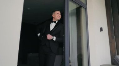 Siyah ceketli beyaz bir adam. Ceketli bir erkek işadamı pencerenin yanında duruyor.