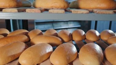 Ahşap rafta fırınlanmış ekmek soğutma. Fırında pişmiş taze gevrek parçaları fırın fabrikasında raflarda yatıyor ve Tezgahlarda Ulaşım için hazır bekliyor. Endüstriyel Ekmek Yapımı.