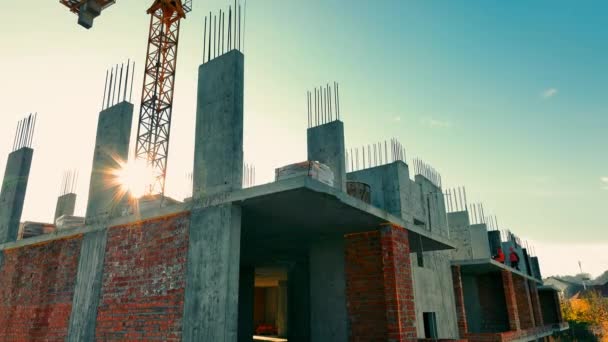 モノリスとブリックマテリアルの組み合わせを活用した新建築プロジェクトの建設 ホイスティングクレーンと新しいマルチステイ住宅のドリング — ストック動画
