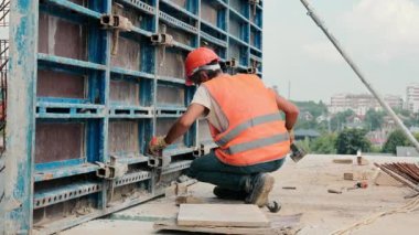 İnşaatçı inşaat alanındaki metal yapıyı tamir ediyor. Metal yapıların monolit ile doldurulması