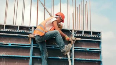 Bir evin inşaatı sırasında bir mühendis metal yapılar kuruyor. Güçlendirilmiş beton için metal yapılar kurulumu