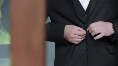 Erkekler takım elbisedeki düğmeleri bağlar. Kapat..