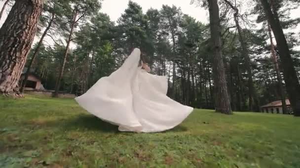 雪だるまのドレスの花嫁が公園で走っています 結婚式からの花嫁の素晴らしい脱出 — ストック動画