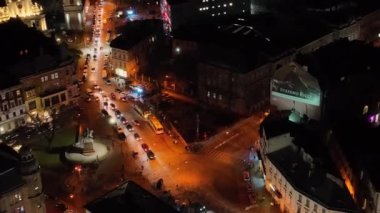 Işıklardaki antik şehir. Uyku alanının yollarındaki trafiğin en üst görüntüsü. Yüksek binalarda ışıklandırma. Hava görünümü.