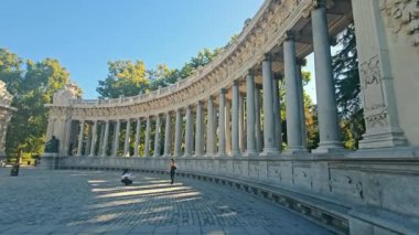 Alfonso XII Colonnade Retiro Park, Madrid, İspanya - Eylül 2023. El Retiro Parkı 'ndaki sütunlarda, iki kadın turist sütunların yakınında fotoğraf çekiyorlar.