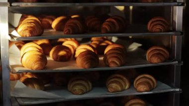 Fırındaki fırında kruvasan pişirdim. Kruvasan yapma konsepti. Kapat.