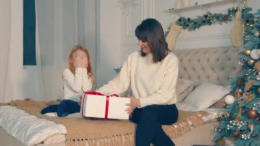 Küçük bir kız yatağında gözleri kapalı oturuyor ve sevgili annesinden bir sürpriz bekliyor. Bir anne kızına hediye verir, mutlu bir çocuk annesine sarılır. Mutlu çocukluk