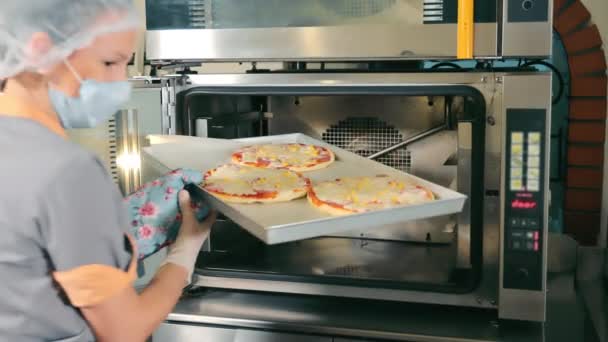 一位餐馆厨师从烤箱里拿出三块披萨 在披萨店里放了一把金属铲子 比萨烘焙工艺 — 图库视频影像