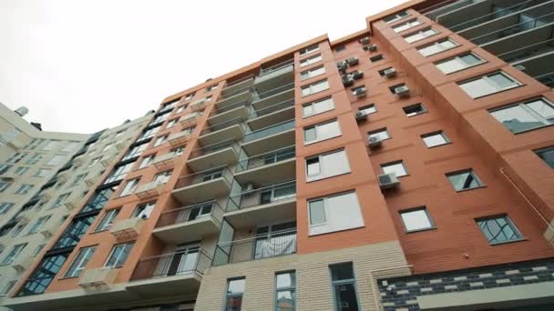 新しく建てられた近代的な多階建て住宅 ファサードとロギャスのエアコン用のバスケット付きのアパートの建物 下から見る — ストック動画