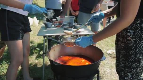 Раздача Еды Голодным Бездомным Беженцам Добровольцы Черпают Красный Суп Борщ — стоковое видео