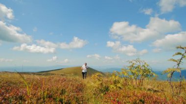 Yorgun turistler dağa tırmanıyor, manzaranın tadını çıkarıyor, su içiyor. Turizm seyahati ve aktif sağlıklı yaşam tarzı konsepti. Ön görünüm