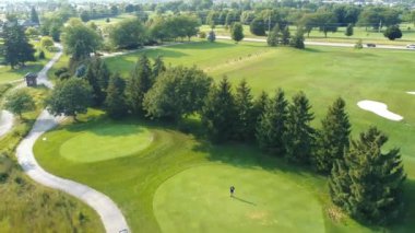 Golf sahasında uçmak, golf sahasında insanlar golf oynamak. Güneşli bir yaz gününde golf oynayan aktif adamlar. Hava görünümü