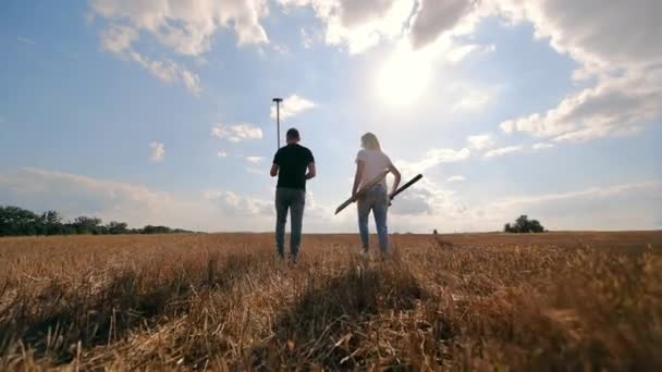 収穫された畑を歩く農民 農業用具を持った男女 フィールド境界の測定 — ストック動画