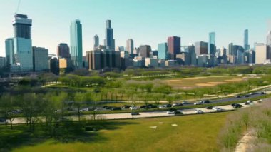 Chicago 'nun Yeşil Şehir Parkı' na bakan Skyline şehri. Chicago Illinois 'in açık mavi gökyüzünün altında sakin bir şehir parkı olan hareketli bir şehrin panoramik manzarası..