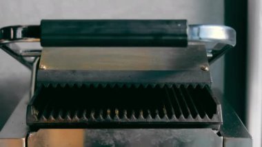 Panini Press 'te ekmek ızgarası, profesyonel bir panini makinesinde ızgara ekmek.