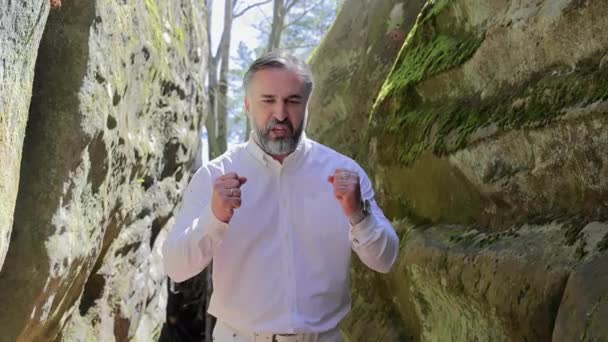 ロッキーキャニオンでエキサイティングな男ジェスチャー 森林の渓谷で話しながら彼の手でジェスチャー — ストック動画