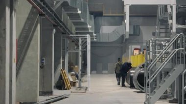 Sanayi Tesisleri Koridoru. Endüstriyel üretim tesisinin koridorundaki işçiler.