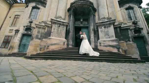 ブライドとグロムが教会のステップに 歴史的な教会のステップにポーズする花嫁とグルーミング — ストック動画