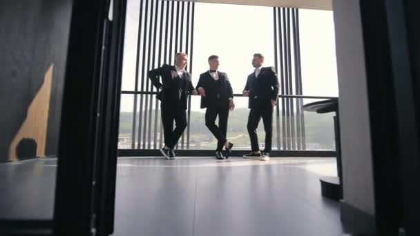 办公室视窗对话中的商人 三个穿着正式服装的商人在俯瞰全市的高高的窗户边聊天 — 图库视频影像