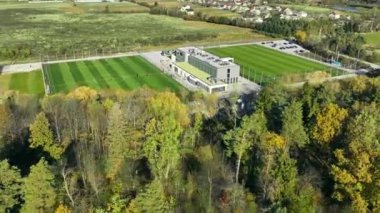 Futbol sahası ve kulüp evinin hava görüntüsü, modern kulüp binasının ve park yerinin yanındaki futbol sahalarının sonbahar ağaçlarıyla çekilmiş görüntüsü.