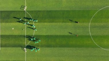 Yukarıdan Futbol Eğitim Oturumu, antrenman sırasında ağaçlarla çevrili yeşil sahadaki futbolcuların üst görünümü