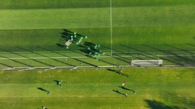 Yukarıdan Futbol Eğitim Oturumu, antrenman sırasında ağaçlarla çevrili yeşil sahadaki futbolcuların üst görünümü