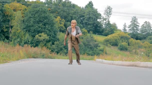 在乡村道路上 醉酒的男子步履维艰 不平等的成年男子挣扎着在偏僻的乡村道路上直走 — 图库视频影像