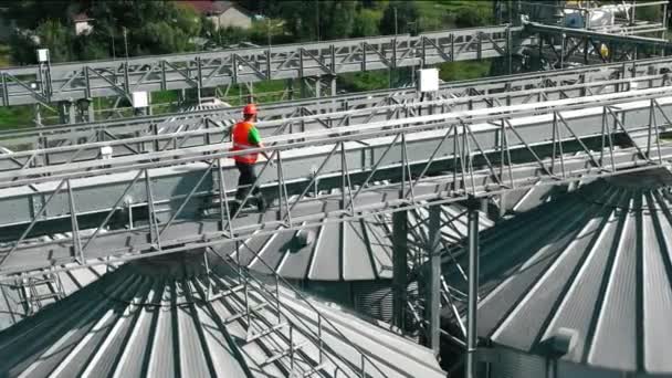 Worker Inspecting Grain Facility Lavoratore Giubbotto Arancione Sulla Passerella Metallica — Video Stock