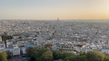 Paris, Fransa 29.09.2023 Günbatımı Paris çatıları üzerinde, gün batımında nefes kesen Paris manzarası, yoğun kentsel manzara ve ikonik çatılar