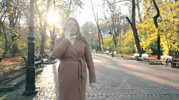 Осенняя Прогулка Городском Парке Женщина Стильном Пальто Телефону Время Солнечной — стоковое видео