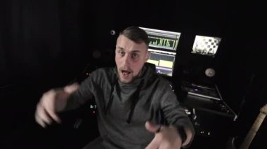 Müzik stüdyosundaki adam, profesyonel bir stüdyo ortamında müzik ekipmanlarıyla meşgul olan genç adam.
