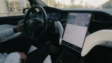 Düsseldorf Almanya 01.03.2024 Electric Car Tesla X modelinde araba kullanan iş adamı. İş elbiseli bir adam dokunmatik ekranlı modern elektrikli bir araç kullanıyor.