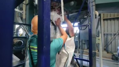 Endüstriyel işçiler Toptan Malzemeleri taşırken iki rahip büyük bir torba tahıl alacak..
