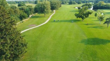 Manzaralı Golf Sahası Hava Perspektifi, Berrak gökyüzünün altında golf oyuncuları ve patikaları olan yemyeşil golf sahası