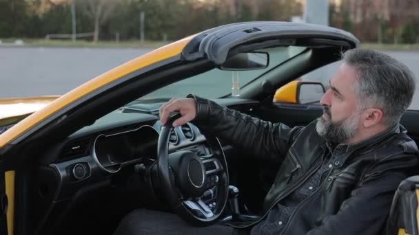 Ένας Άντρας Αυτοπεποίθηση Κάθεται Ένα Κίτρινο Σπορ Αυτοκίνητο Ώριμος Άνδρας — Αρχείο Βίντεο