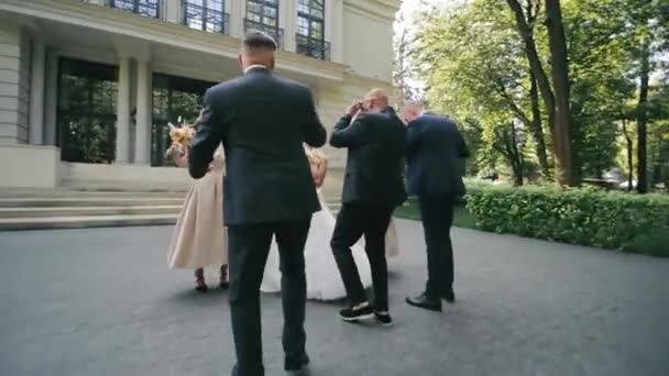 新婚夫妇和新郎与朋友在一个盛大的婚礼场地的台阶上举行婚宴 — 图库视频影像