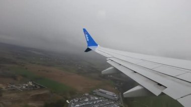 Krakow Polonya 1.04.2024 Kırsal Arazi Üzerinde Yükselen Uçak Kanadı kırsal bir arazide süzülen kanat penceresinden, küçük kasabalar ve bulutlu gökyüzü