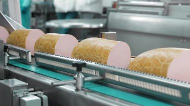 Otomatik Sosis Paketleme Hattı, büyük sosis parçaları bir sosis üretim tesisinde ambalaj hattı boyunca ilerliyor..