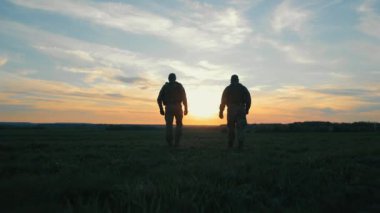 Günbatımına Karşı Ukrayna askerleri kamuflajlı iki askerin gün batımında ufka doğru yürüdüğünü görüyorlar. Ukrayna 'da Savaş.