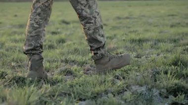 Sahada asker botları, çimlerin üzerinde askeri botlar, devriye sırasında asker ayakkabısının detaylarını ve dokusunu yakalamak.