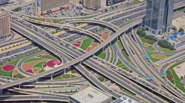Dubai 'deki Karmaşık Otoyol Kavşağı' nın Havadan Görünümü, Dubai 'deki yemyeşil peyzaj ve birden fazla karayolu ile renkli ve karmaşık bir otoyol kavşağının tepeden aşağı görüntüsü.