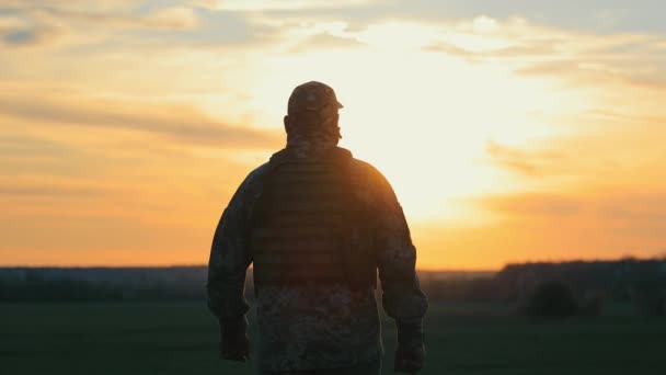 Ένας Στρατιώτης Περπατά Στο Ηλιοβασίλεμα Μια Σιλουέτα Ενός Στρατιώτη Κινείται — Αρχείο Βίντεο