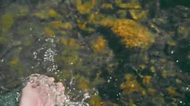 Tazeleyen suya dokunmak, suyun berrak ve ferahlatıcı bedenine uzanan bir el, temas anını yakalıyor..