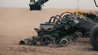 Tohum ekici, ekili bir tarlada çalışan tarım makinelerinin detaylı bir görüntüsü karmaşık ekipmanlar toprağı ekime hazırlıyor.