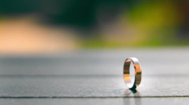 Ahşap bir yüzeyde yan yana duran iki alyans, saatin ayrılığını ve ızdırabını güçlendirir.