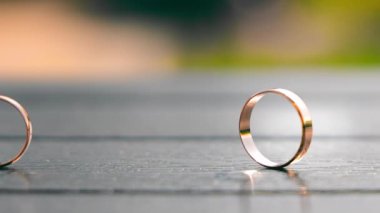 Ahşap bir yüzeyde yan yana duran iki alyans, evlilikteki birlikteliğin ve bağlılığın sembolünü vurgular.